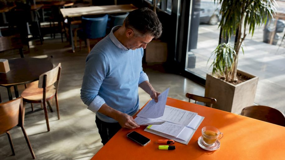 Host reviewing guest registration forms at desk